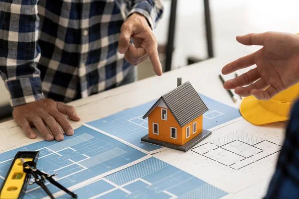 Architects design team is looking at models of small houses, Architect engineers design houses and interiors and draw floor plans through design program. Architect concept of building design.