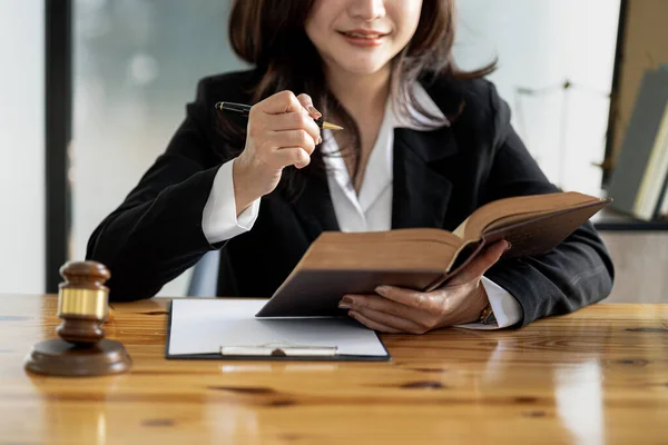 A woman sits and reads a law book, she is a lawyer serving clients to fight cases, she gives advice and fights in various cases. that has been fully acknowledged. Lawyer concept and justice.