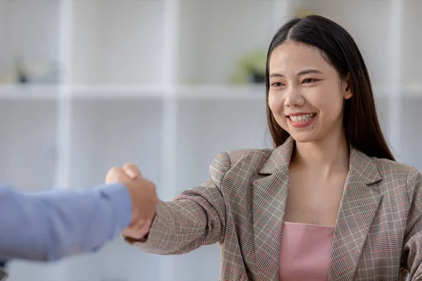 Two businessmen shake hands, they are shaking hands as they meet to discuss brainstorming and marketing plans to find more profitable ways to grow. Business management ideas for profitable growth.