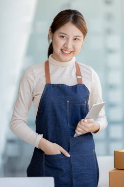 Online mağaza platformunda ürün satan bir şirketin kadın sahibi, bir kurye şirketi aracılığıyla mal gönderen, iş planlayan. Çevrimiçi satış ve online alışveriş kavramları.