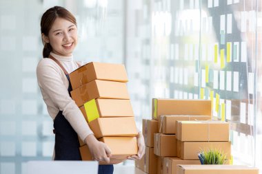 Online mağaza platformunda ürün satan bir şirketin kadın sahibi, bir kurye şirketi aracılığıyla mal gönderen, iş planlayan. Çevrimiçi satış ve online alışveriş kavramları.