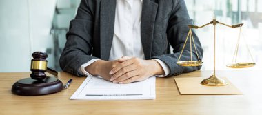 Bir avukat, elinde küçük bir çekiçle, ofisinde oturuyor. Mahkemede hakimin masasını yenmek için. Ve adalet terazileri, avukatlar müvekkilin imzalaması için bir sözleşme hazırlıyorlar..