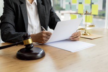 Avukatlar, müvekkilin dolandırıcılık yapan bir şirkette çalışan bir çalışana dava açtığı sözleşme belgelerini gözden geçiriyorlar. Dolandırıcılık davası kavramı.
