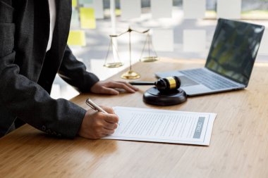 Avukatlar, müvekkilin dolandırıcılık yapan bir şirkette çalışan bir çalışana dava açtığı sözleşme belgelerini gözden geçiriyorlar. Dolandırıcılık davası kavramı.