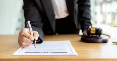 Avukatlar, müvekkilin dolandırıcılık yapan bir şirkette çalışan bir çalışana dava açtığı sözleşme belgelerini gözden geçiriyorlar. Dolandırıcılık davası kavramı.