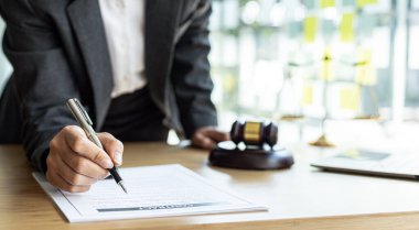 Avukatlar, müvekkilin dolandırıcılık yapan bir şirkette çalışan bir çalışana dava açtığı sözleşme belgelerini gözden geçiriyorlar. Dolandırıcılık davası kavramı.