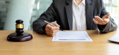 Avukatlar, müvekkilin dolandırıcılık yapan bir şirkette çalışan bir çalışana dava açtığı sözleşme belgelerini gözden geçiriyorlar. Dolandırıcılık davası kavramı.