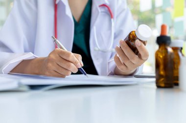 Eczacı ilaç listesini inceliyor ve sahip olduğu eczanelerden, eczanelerinden ve tıbbi gereçlerinden birindeki tüm ilaçların stoklarını kontrol ediyor. Eczane kavramı.
