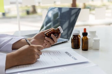 Eczacı ilaç listesini inceliyor ve sahip olduğu eczanelerden, eczanelerinden ve tıbbi gereçlerinden birindeki tüm ilaçların stoklarını kontrol ediyor. Eczane kavramı.