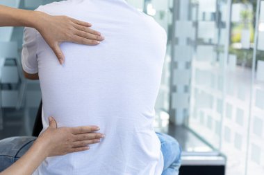 Fizyoterapist bir hasta için fizik tedavi uyguluyor, hastanın aşırı çalışma nedeniyle vücut ağrıları var ve profesyonel bir fizyoterapistle tedavi ve fizyoterapi görüyor..