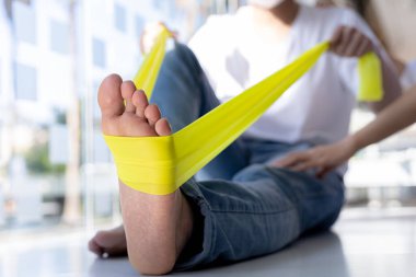 Fizyoterapist bir hasta için fizik tedavi uyguluyor, hastanın aşırı çalışma nedeniyle vücut ağrıları var ve profesyonel bir fizyoterapistle tedavi ve fizyoterapi görüyor..