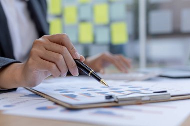 İşadamı mali belgelere işaret ediyor, bir şirket kuruyor, şirketin mali özetini kontrol ediyor ve finans departmanı tarafından hazırlanıyor. Girişim şirketinin yönetim kavramı.