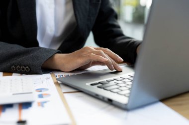 Özel bir odada çalışan bir iş kadını dizüstü bilgisayarda klavye kullanıyor ortağıyla sohbet etmek için kurye kullanıyor. İletişim için teknoloji kullanma kavramı.