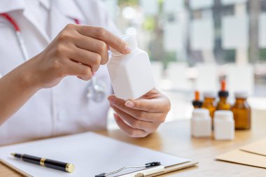 Eczane bir şişe tutuyor, sağlık alanında uzmanlaşmış bir halk sağlığı uzmanı, tüm ilaçlardan, tedariklerinden, üretiminden ve dağıtımından sorumlu..