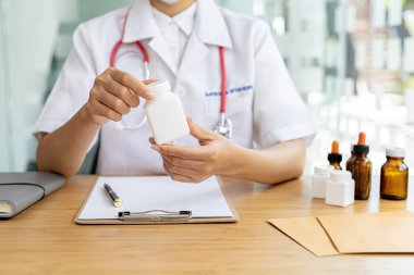 Eczane bir şişe tutuyor, sağlık alanında uzmanlaşmış bir halk sağlığı uzmanı, tüm ilaçlardan, tedariklerinden, üretiminden ve dağıtımından sorumlu..