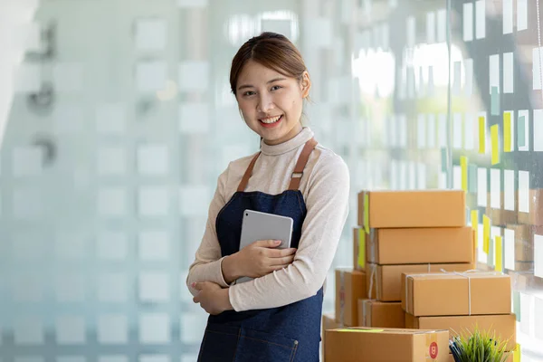 Woman owner of a startup company selling products online on an online store platform, sending goods through a courier company, Business planning. Online selling and online shopping concepts.