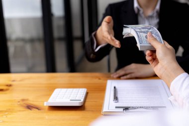 İki insan birbirine dolar dağıtıyor. İkisi de kârlı iş ortakları. Ticari çıkarlar için rüşvet sahtekarlığı yapıyorlar. Yozlaşma ve rüşvet kavramı.