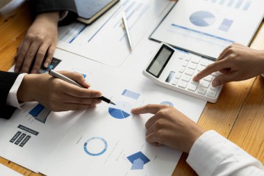 Two businessmen are reviewing the earnings summary and company financial documents that each department produces and submits for monthly audits. Concept of checking company information sheet.