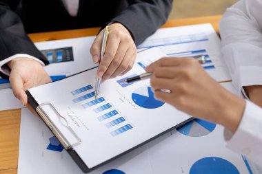 Two businessmen are reviewing the earnings summary and company financial documents that each department produces and submits for monthly audits. Concept of checking company information sheet.