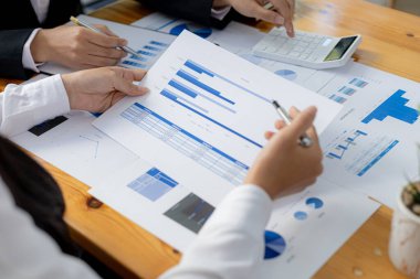 Two businessmen are reviewing the earnings summary and company financial documents that each department produces and submits for monthly audits. Concept of checking company information sheet.