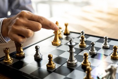 Satranç tahtası oyunu oynayan kişi, iş adamı konsepti imajı ticari rekabet ve risk yönetimi gibi satranç taşları tutan, iş stratejileri planlayan rakiplerini yenmek için iş stratejileri.