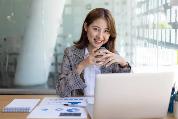 Asian woman sitting in a private office, she is a young businesswoman, female leader, Asian woman consent to be a leader and leader, working woman. Concept of business woman.