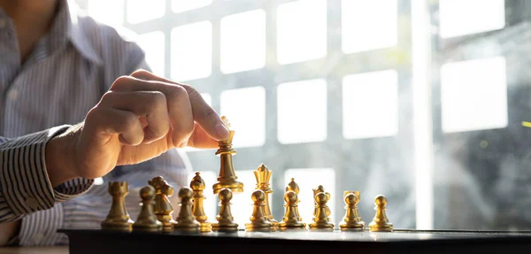 Pessoa Jogando Jogo De Tabuleiro De Xadrez, Homem De Negócios Conceito  Imagem Segurando Peças De Xadrez Como A Concorrência De Negócios E Gestão  De Risco, Planejamento De Estratégias De Negócios Para Derrotar Os  Concorrentes De