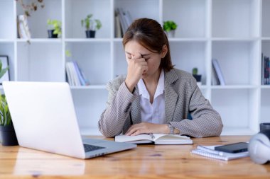 Asyalı bir kadın uzun zamandır bilgisayarında online çalışmaktan bıktı, o bir öğrenci. Sınıfta bir salgını önlemek için COVID-19 salgını nedeniyle çevrimiçi öğrenme kavramı.