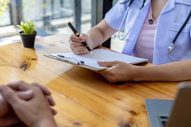 Doktor muayenenin sonuçlarını bildiren bir belge gösteriyor, doktor bulunan testlerin sonuçlarını ve tedavi yönergelerini açıklıyor. Muayene ve hastalık tedavisi kavramı.