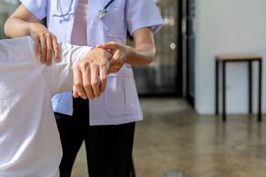 Fizyoterapist bir hastaya fizik tedavi uyguluyor. Çok çalışmaktan dolayı kas bozukluğu yaşıyor. Çoğu zaman uzun süre oturma sorunu olan bir ofis çalışanı..