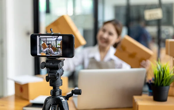 Two women are online sellers, online sales company concept, two female salespeople are live selling products through the shop page and the order screen that customers have ordered and paid.