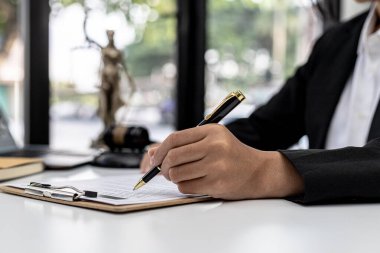 Bir erkek avukat, dolandırıcılık davasında müvekkilinin dolandırıcılık yapan bir şirkette çalışana dava açtığı bir savunma anlaşması imzalıyor. Dolandırıcılık davası kavramı.