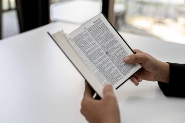 Bir insan İncil okuyor, İncil 'e dua ediyor, İncil okuyor ve okuyor. Hıristiyanlık ve İncil Çalışması kavramı.