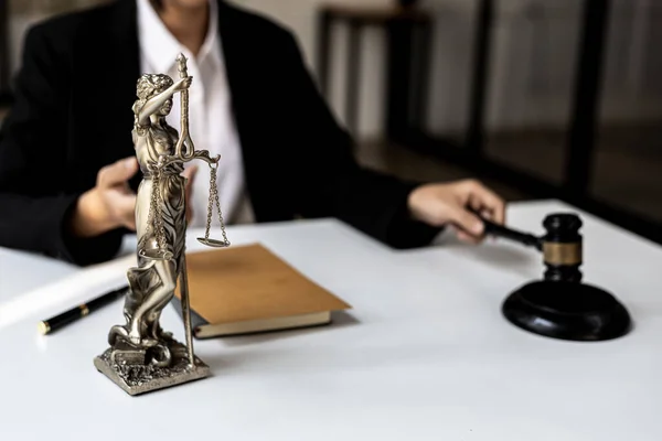 Lawyer\'s Desk On the table is a statue of Themis who is the goddess of justice and the hammer of justice, lawyers often praise her as a symbol of justice. Concept of law and justice.