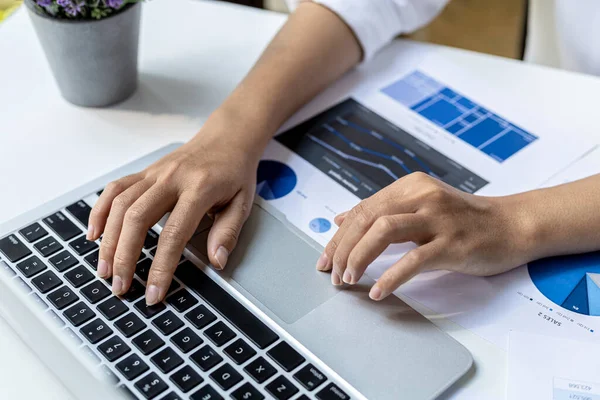 A businesswoman is checking company financial documents and using a laptop to talk to the chief financial officer through a messaging program. Concept of company financial management.