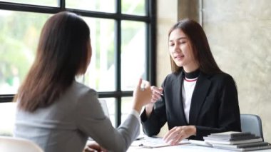 İki güzel Asyalı kadın şirket toplantı odasında buluşup iş planlarını geliştirme planlarını tartışıyorlar. İş görüşmesi fikri.