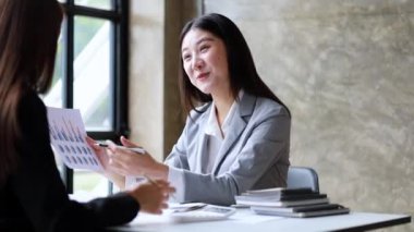 İki güzel Asyalı kadın şirket toplantı odasında buluşup iş planlarını geliştirme planlarını tartışıyorlar. İş görüşmesi fikri.