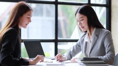 İki güzel Asyalı kadın şirket toplantı odasında buluşup iş planlarını geliştirme planlarını tartışıyorlar. İş görüşmesi fikri.