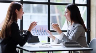 İki güzel Asyalı kadın şirket toplantı odasında buluşup iş planlarını geliştirme planlarını tartışıyorlar. İş görüşmesi fikri.