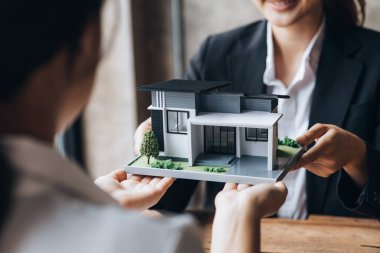 Real estate agents are carrying a housing model of the project to be forwarded to customers as home delivery. Real estate trading ideas and bank loans for buying and selling houses and land.