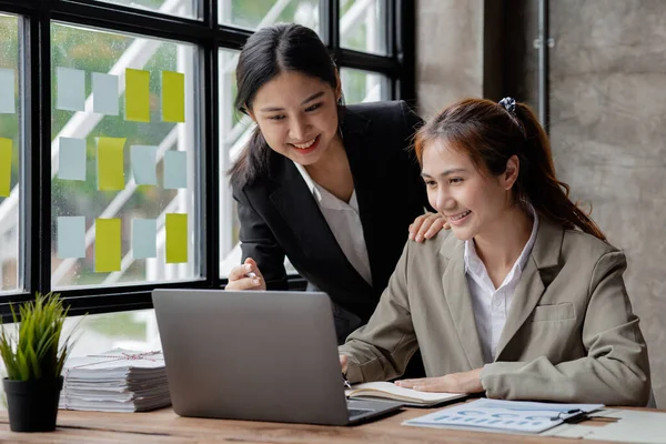 Two Asian business women are meeting to summarize the company\'s operating, financial, profit and loss results. Management of startup companies. Profitable management concept and growing management.