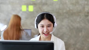 Güzel bir Asyalı kadın, bir internet ve telefon şirketinde çağrı merkezi çalışanı, telefon aracılığıyla müşterilere hizmet ve yardım sağlamaktan sorumludur. Çağrı merkezi kavramı.