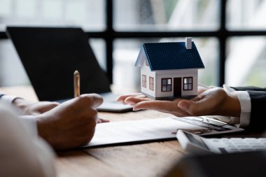 Emlakçılar projenin bir konut modelini müşterilere ev teslimatı olarak gönderiyorlar. Emlak ticareti fikirleri ve banka kredileri ev ve arazi alım satımı ve satımı için.