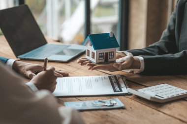 Real estate agents are carrying a housing model of the project to be forwarded to customers as home delivery. Real estate trading ideas and bank loans for buying and selling houses and land.