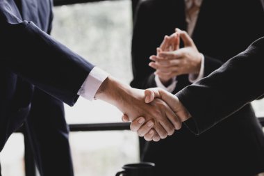 Close-up two business men holding hands, Two businessmen are agreeing on business together and shaking hands after a successful negotiation. Handshaking is a Western greeting or congratulation.