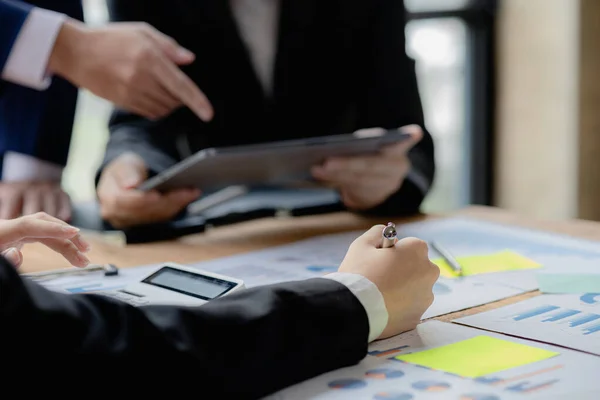 Company meeting room has businessmen and finance managers meeting together on finance topics, they are looking at information on documents and discussing together. Concept company financial management