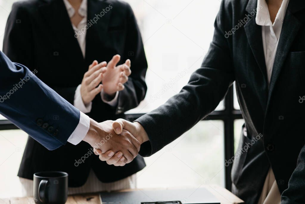 Close-up two business men holding hands, Two businessmen are agreeing on business together and shaking hands after a successful negotiation. Handshaking is a Western greeting or congratulation.