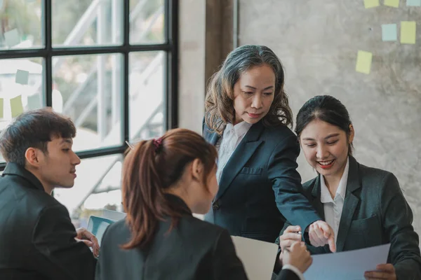 Senior businesswoman with senior executives talking in a meeting, she is meeting with department head staff at a conference room, senior female executives and new generation employees working together