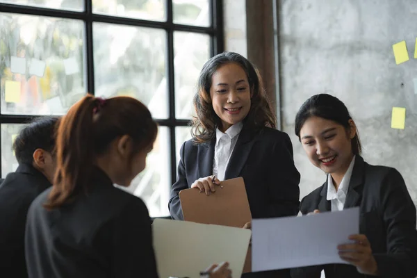 Senior businesswoman with senior executives talking in a meeting, she is meeting with department head staff at a conference room, senior female executives and new generation employees working together