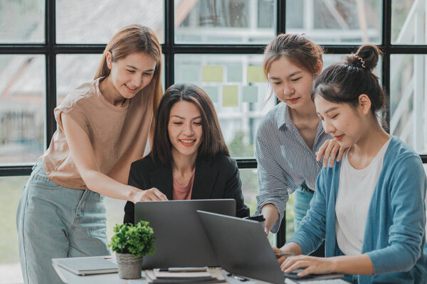 A group of young Asian business women stand and talk. Jointly open a startup company and a business plan management plan to grow the business and be profitable by the concept of the new generation.